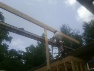 Carpenter setting a ridge beam over a new addition frame — Ice Dam Removal by Roofing Brothers in Tigerton