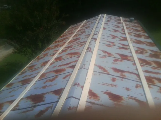 Rusted metal roof panels with new wood purlins before replacement — Storm Damage Roof Repair in Tigerton by Roofing Brothers